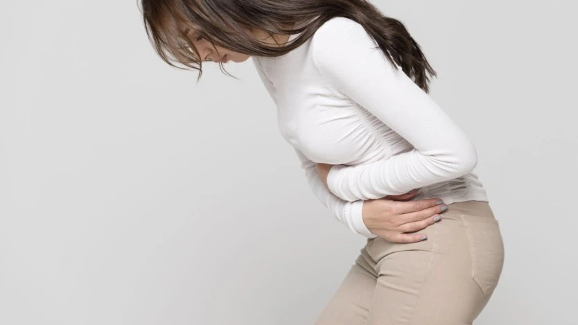 Femme se tordant de douleur à cause de douleurs abdominales