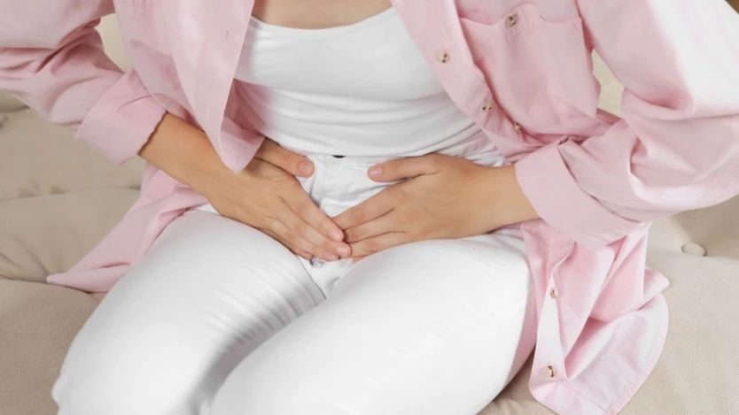 Femme se touchant le ventre en raison de douleurs et d'inconfort
