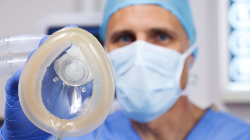 Anesthésiste tenant un masque pour administrer l'anesthésie